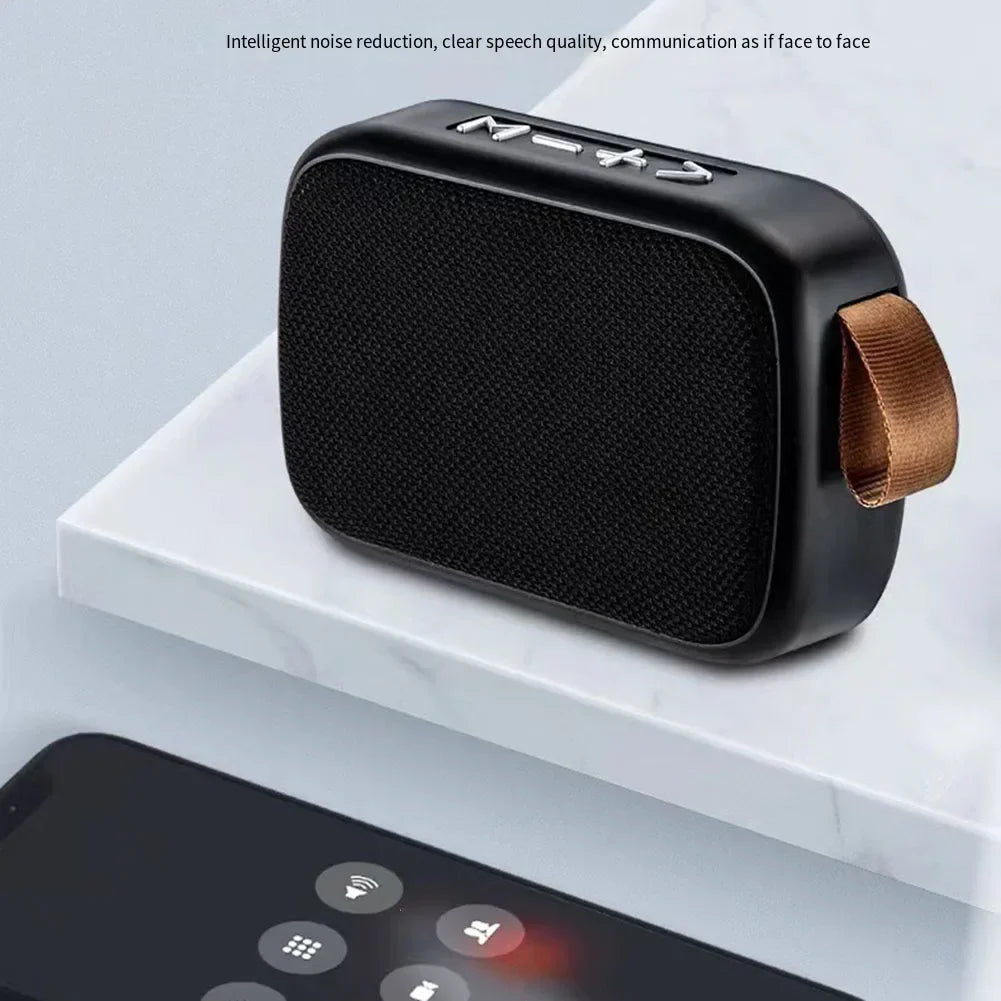 Black portable speaker on a white surface with smartphone below